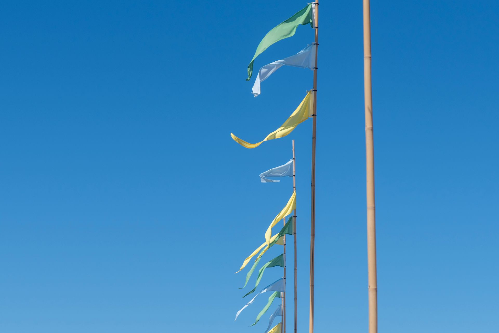 Event flags on tall poles against a blue sky, a simple event branding idea for outdoor venues