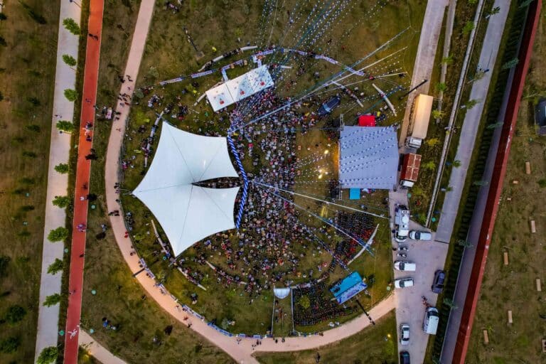 Event branding ideas in action: aerial view of an outdoor festival with stretch tent, stage and branded stands