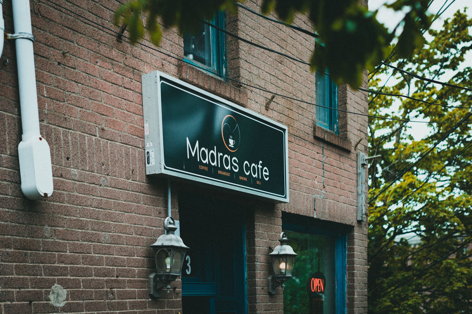 Illuminated shop signage lightbox mounted above an independent cafe entrance